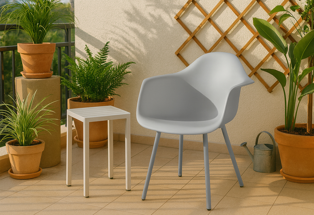 Απεικονίζεται η πολυθρόνα Curve σε μια βεράντα, δίπλα από ένα τραπέζι.